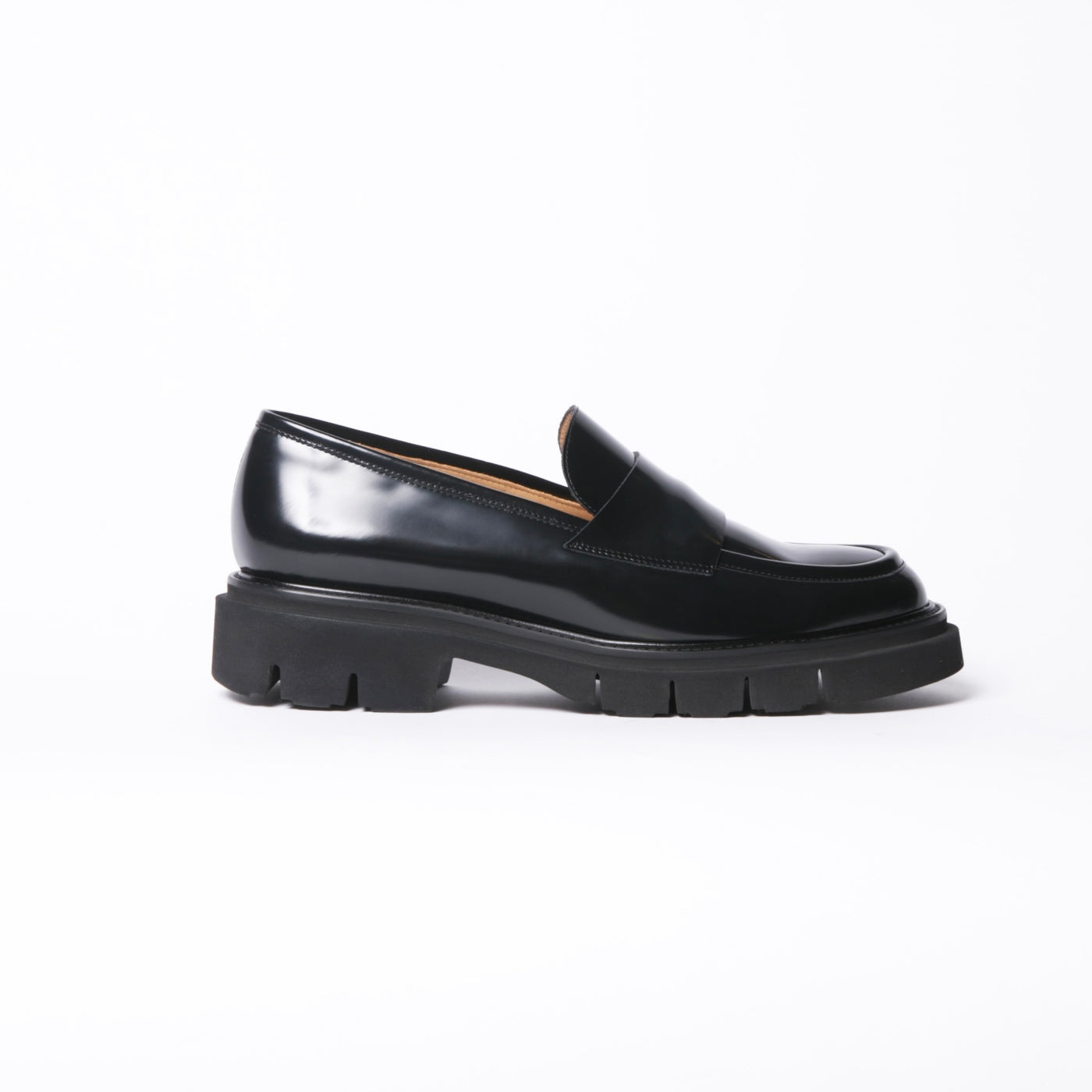 Chunky black patent leather loafers with light rubber soles. 