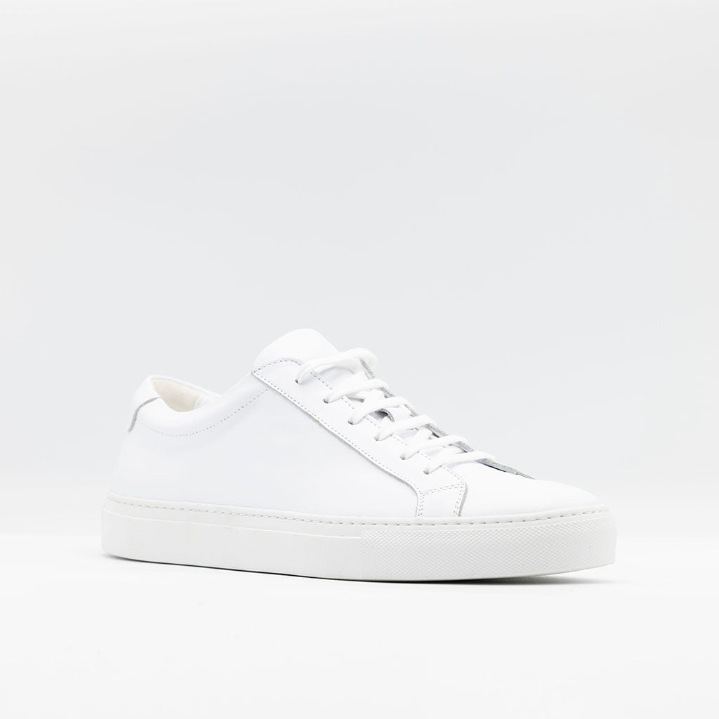 Mens classic sneakers in white leather set on white rubber soles. Classic sneaker model. 
