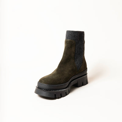 Ankle boots in green suede with chunky rubber soles. .