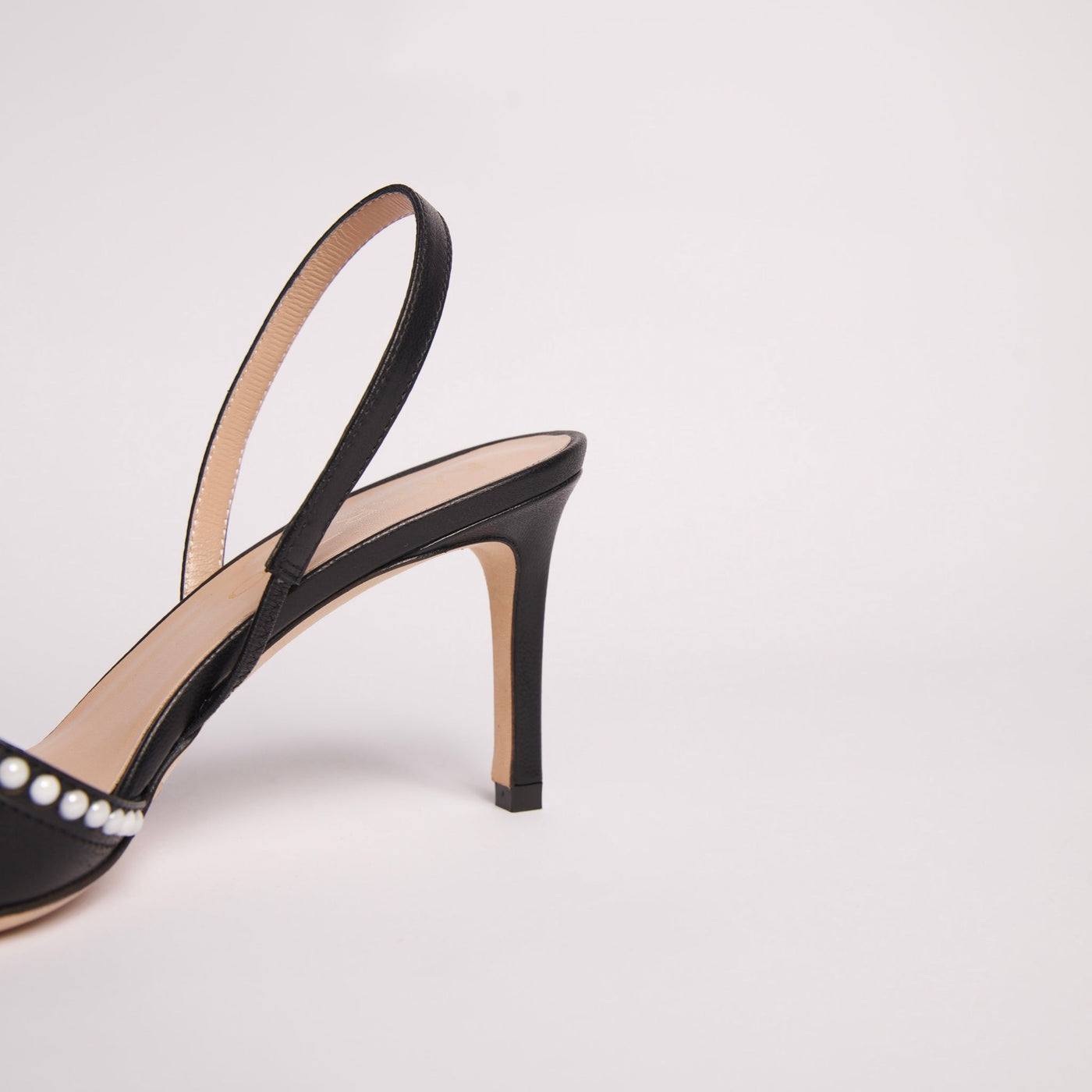 Black slingback pump with decorative pearls and bow.