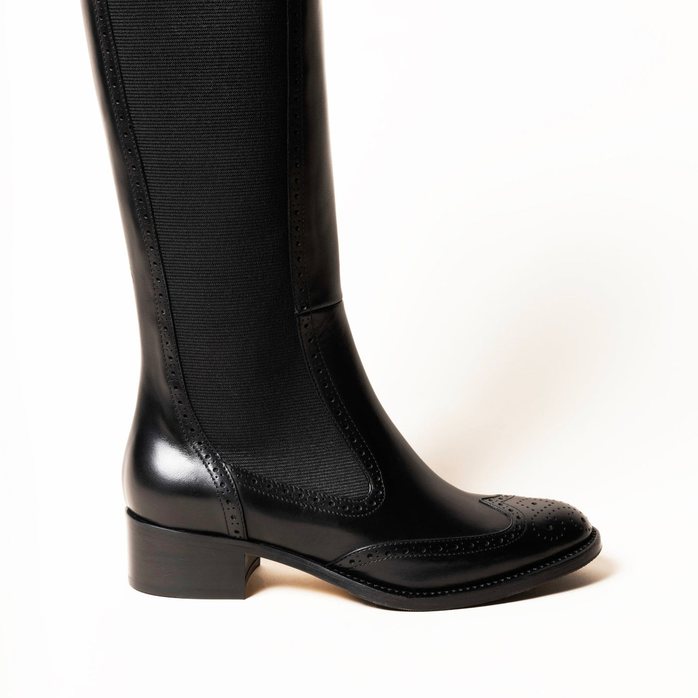 Black leather riding boot with brogue pattern. 
